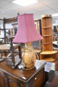 A modern turned wood table lamp and burgundy shade