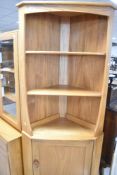 An Ercol 'golden dawn' style corner shelf having cupboard under, height approx. 180cm