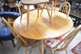 A traditional Ercol light stain drop leaf dining table and six hoop and stick back dining chairs