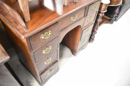 A 19th Century mahogany wash stand in the kneehole desk style having ledge back and replaced brass