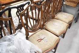 A set of four shield back dining chairs having drop in embroidered seats