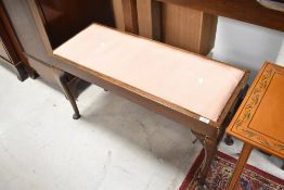 An early 20th Century duet stool having drop in seat and cabriole legs, width approx. 93cm