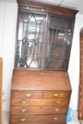 A Georgian and later mahogany bureau having matched astral glazed bookcase over