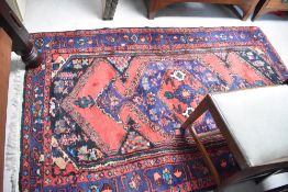 A traditional wool persian style rug, approx. 215 x 132cm