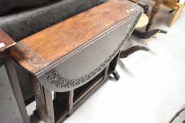 An Arts & Crafts oak gateleg table having carved decoration, width approx.92cm