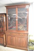 An early 20th Century mahogany bookcase having astral glazed top section over two drawers and double