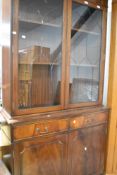 A reproduction Regency bookcase with double cupboard under, width approx. 99cm
