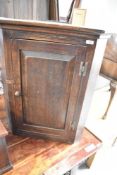 A traditional oak corner cupboard of small proportions, height approx. 81cm