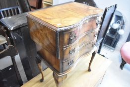 An early to mid 20th Century walnut occasional chest of three drawers having serpentine front and