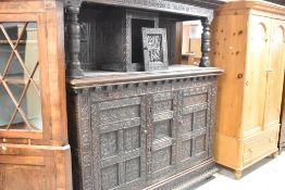 A large and impressive 18th Century oak court cupboard, profusely later carved and bearing date