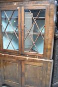 A Georgian corner cabinet having glazed upper section and cupboard base