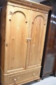 A natural pine single wardrobe, on single drawer base, width approx. 110cm