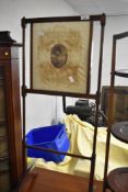 A fine Edwardian mahogany fire screen having pictorial silk inset