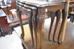 A walnut nest of three tables having cabriole legs