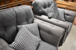 A pair of modern grey chesterfield style armchairs, and complimentary loose cushions