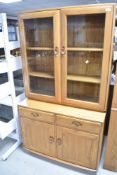 An Ercol 'golden dawn' style bookcase having cupboard under, width approx. 91cm