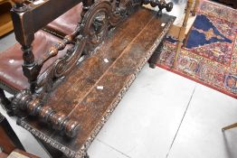 A 19th Century oak window seat having carved decoration and turned arms, width approx. 123cm