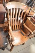 A 19th Century stained frame kitchen arm chair having railback