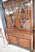 An early 20th period style bookcase having glazed top section , two drawers and cupboard below,