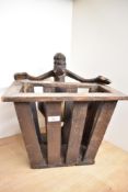 An unusual carved wooden tribal souvenier newspaper rack having Papua New Guinea figure, h38cm