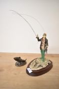 A Border Fine Arts figure 'Fly Fisherman' having damage to rod sold along with a Bronze Age Salmon