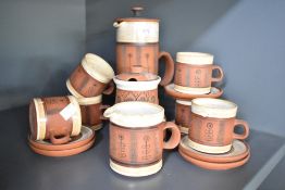 A G. Fox studio pottery tea service decorated with floral patterns on a burnt red ground, makers