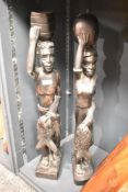 A pair of carved hard wood African tribal sculptures each carrying fish and vessels, h69cm