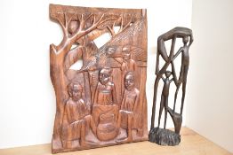A hand carved African themed wooden wall plaque sold along with a similar themed carved abstract