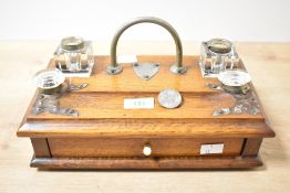 A late 19th / early 20th century oak stationary box having drawer, metal mounts and glass ink wells,