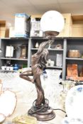 A large resin Art Noveau style table lamp depicting a female holding up the light, measuring 65cm