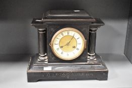 A 19th century black 8 day mantel clock having black Roman numerals on a cream chapter ring with a