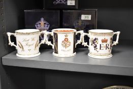 A group of three Royal Crown Derby porcelain commemorative loving cups, produced to commemorate