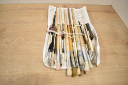 A small roll of paint brushes, in used condition.