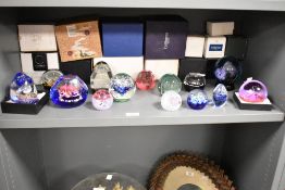 A collection of fourteen glass paperweights, eleven being Caithness, to include 2015 Commemorating