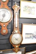 A late19th century banjo barometer having temperature gauge, decorated with exotic birds and
