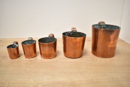 A graduating set of six 19th century copper measures, each with loop handle, 1/2 gill to quart, five