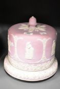 A late 19th century / early 20th century pink Jasperware cheese dome, having acorn finial, decorated