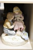 An early 20th century German painted ceramic figure of a boy and girl, h37cm
