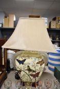 An oriental style table lamp having floral decoration with butterflies on cream porcelain,