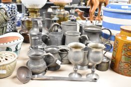 An assortment of Pewter ware and similar to include steins, condiment pots and candlesticks etc.