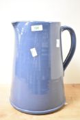 A large blue ceramic pitcher having shaped handle and spout, h32cm