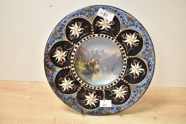 A 19th century Hubert Sattler pottery charger, the centre hand painted depicting a Swiss landscape
