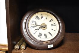 A vintage Continental painted metal circular wall clock, with exposed movement and two cylindrical