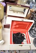 A faux leather cream jewellery box, containing a small collection of costume jewellery, along with a