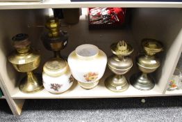 A brass vintage oil lamp with smoke glass shade decorated with foliage, largest h25cm, sold together