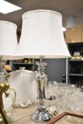 A pair of modern metallic table lamps, measuring 69cm respectively, shades included.