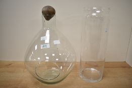 A clear glass display vase with stopper, h35cm, sold together with a cylindrical glass vase, (2)