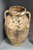 A large terracotta olive jar of baluster form, h38cm