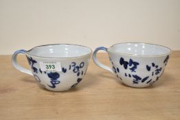 A pair of Japanese style cups hand coloured with Rabbits and calligraphy, h7cm,(2)