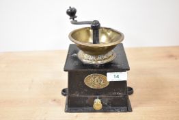 A cast metal coffee grinder having brass funnel and shaped handle, makers plaque for A. Kenrick &